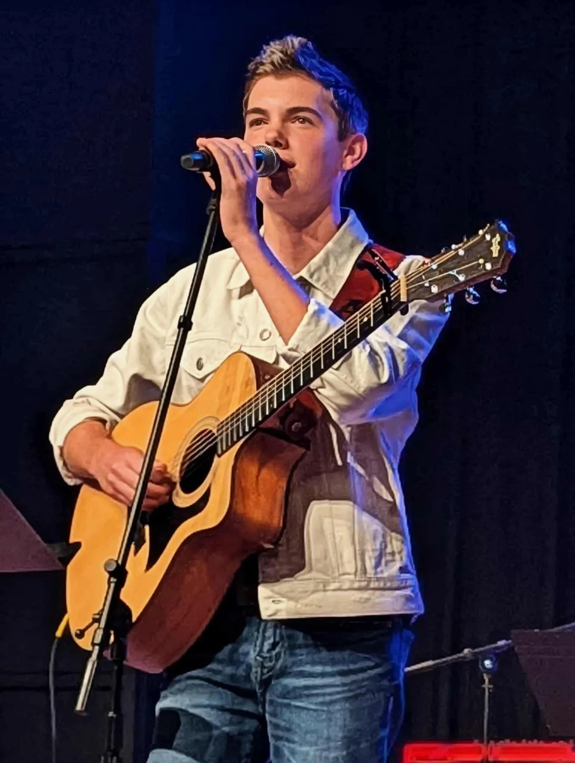 AJ Robinson performing live under blue stage light