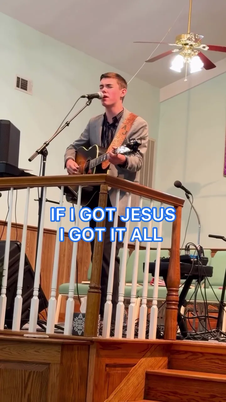 AJ Robinson playing acoustic guitar and singing in his church